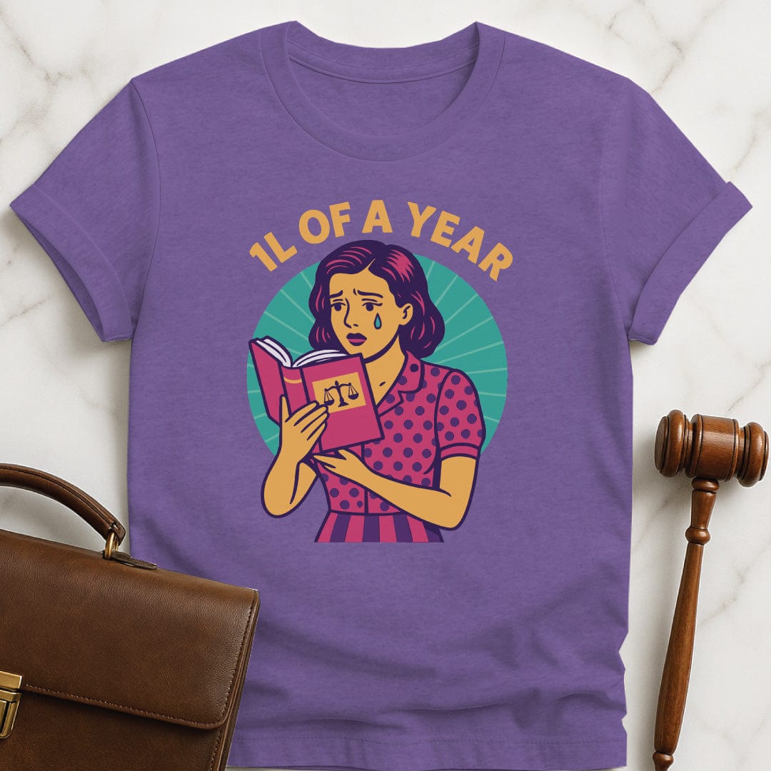 cool law school graphic tee that says 1L of a Year featuring comic book woman holding a law textbook and crying in heather purple