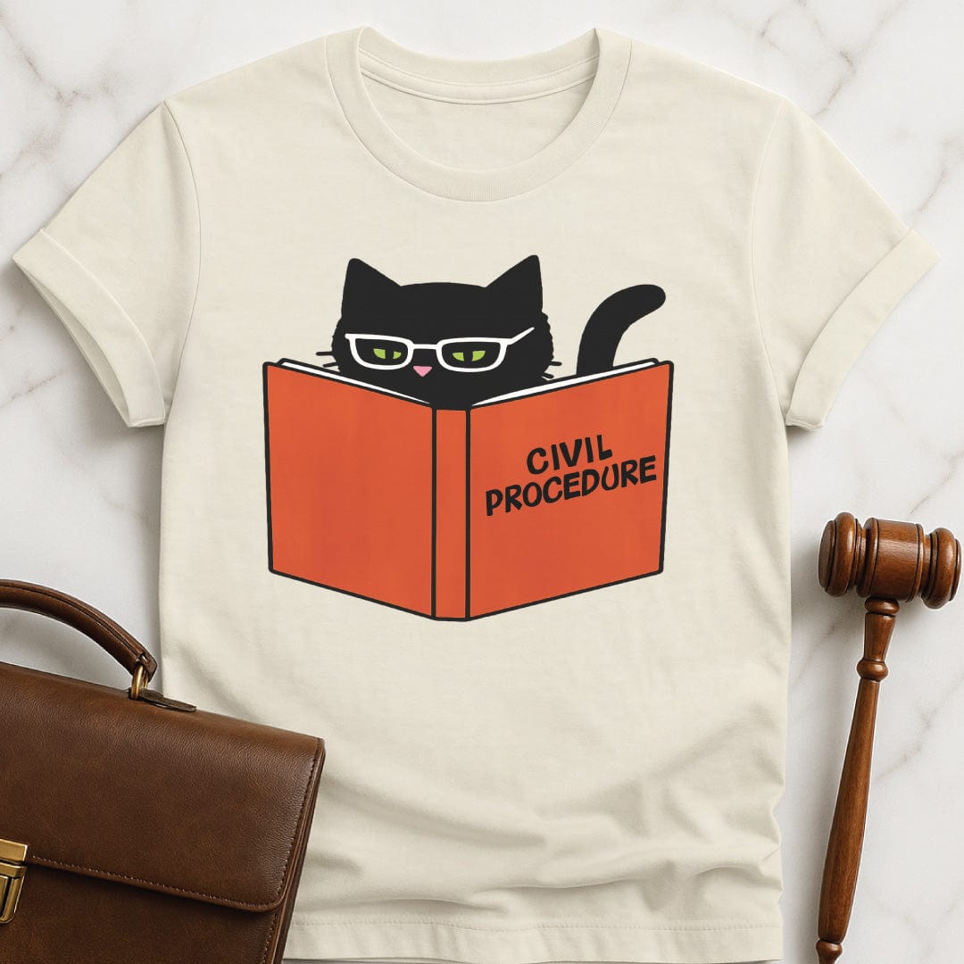 cute law school graphic tee that says civ pro cat featuring a black cat reading a civil procedure case book in cream