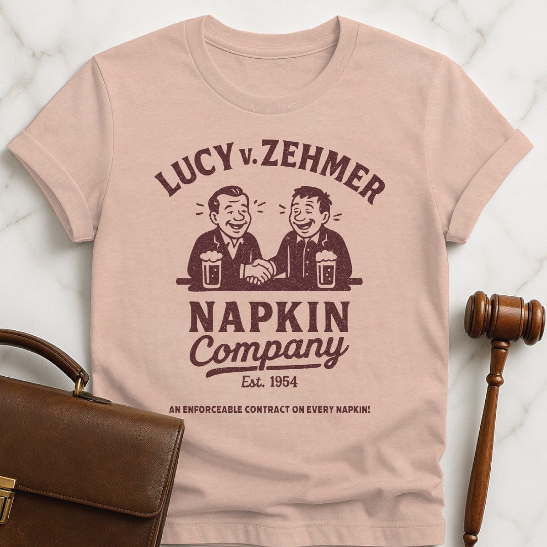 cool law school graphic tee that says Lucy v Zehmer Napkin Company Est 1954 featuring two men drinking beer and shaking hands in heather peach