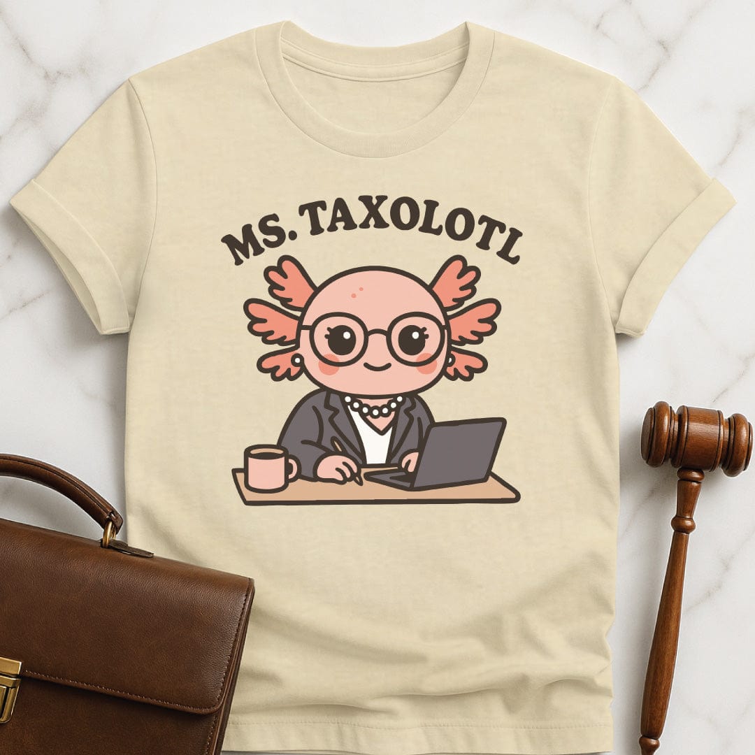 cute lawyer t shirt that says Ms Taxolotl featuring axolotol in a business suit and pearls at a desk with a laptop and a mug in cream