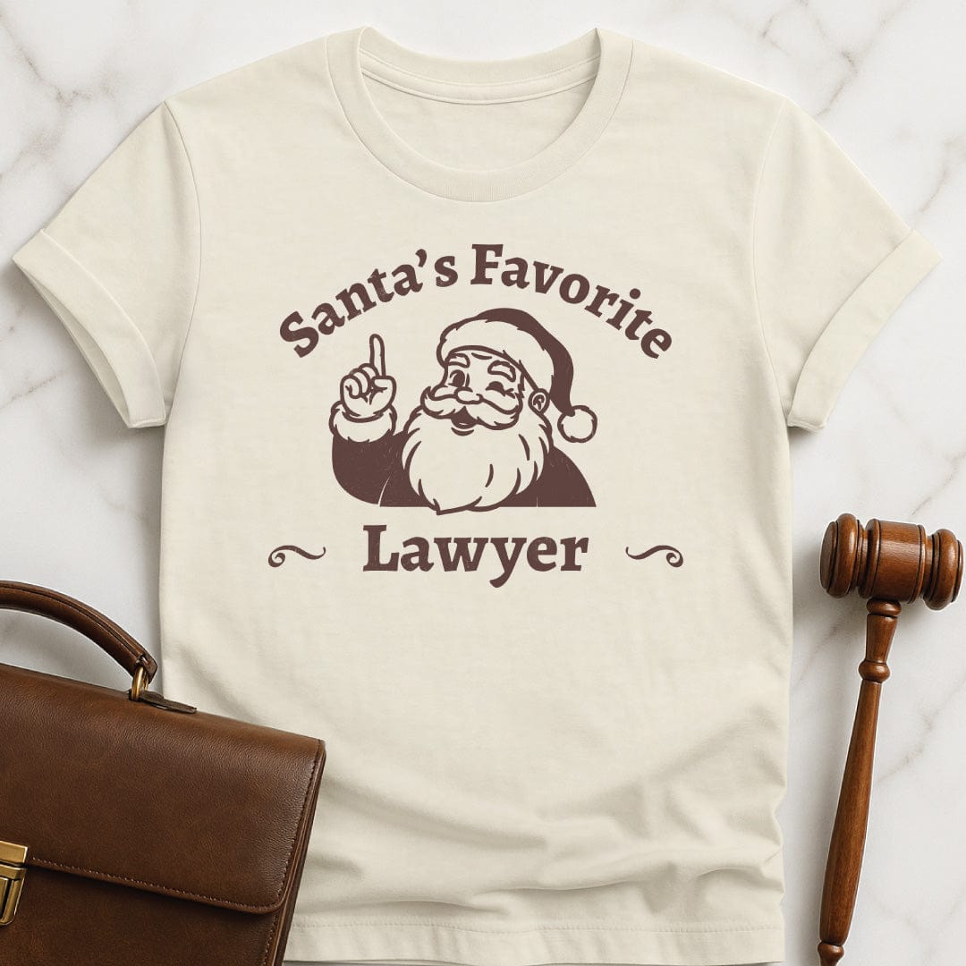 santa law grad t shirt that says Santas Favorite Lawyer featuring Santa holding up a finger in cream