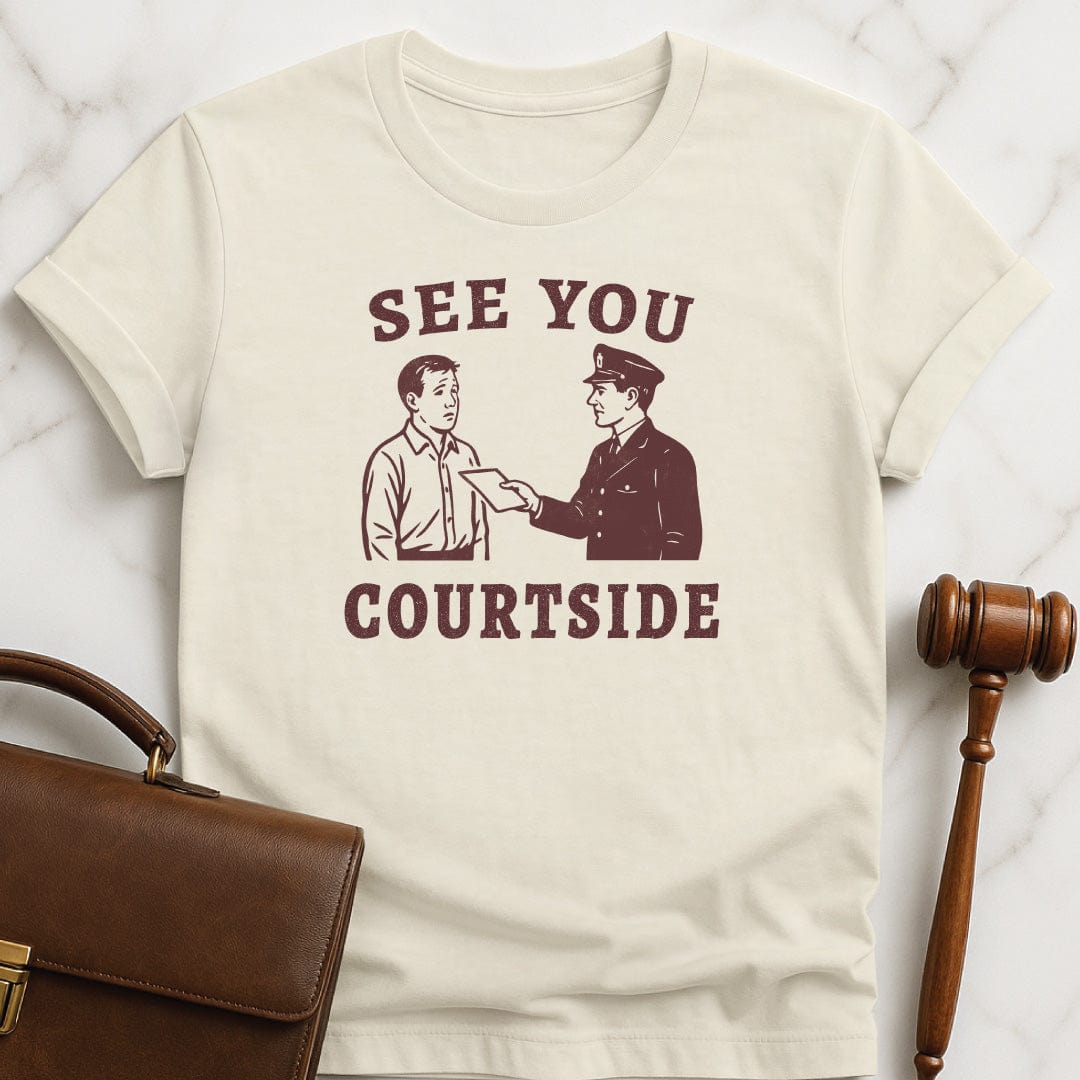 unique law grad graphic tee that says See You Courtside featuring police officer handing a person a piece of paper in cream