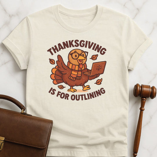 cute law student graphic t shirt that says thanksgiving is for outlining featuring a turkey in a scarf and glasses holding a laptop in cream