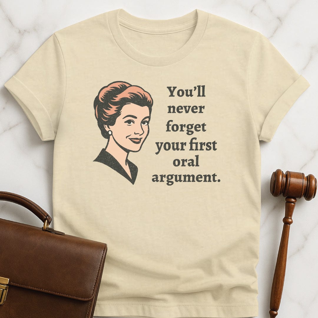 retro law school graphic t shirt that says You Never Forget Your First Oral Argument featuring A retro woman in cream