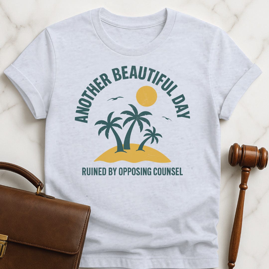 clever law school graduate tee that says Another beautiful day ruined by opposing counsel featuring palm trees on a tropical island with sun and birds in grey