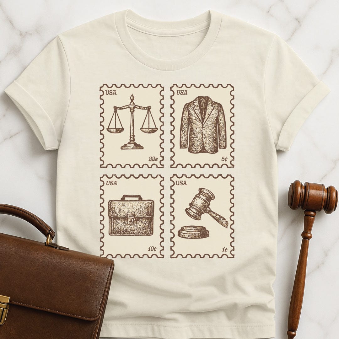 cute new lawyer graphic t shirt featuring antique vintage style stamps of brief case scales of justice gavel and a suit jacket in cream
