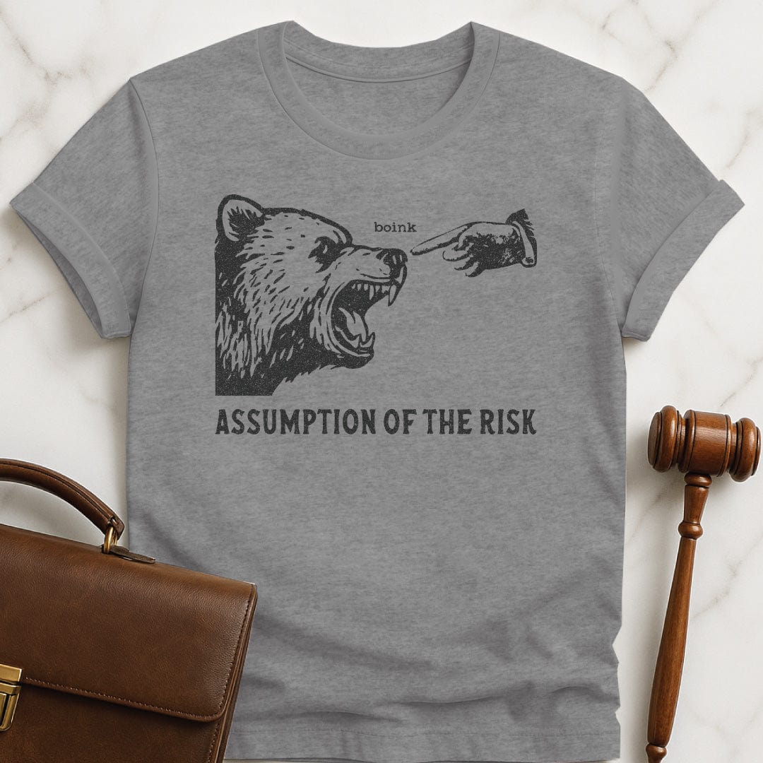 funny law graduate tshirt that says Assumption of the risk featuring a hand about to tap a growling bear on the nose and the text boink in grey