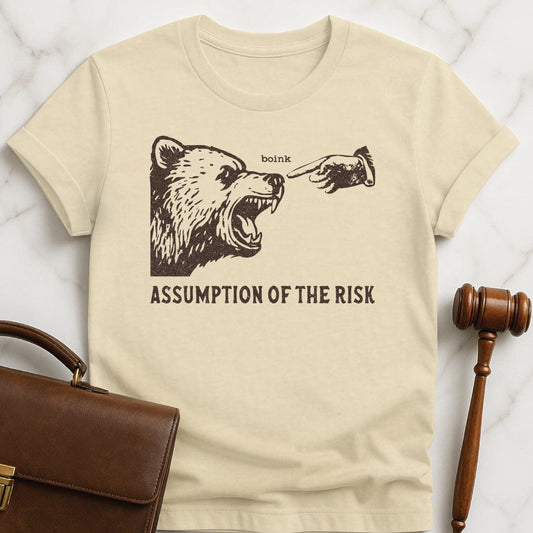 cool lawyer graphic t shirt that says Assumption of the risk featuring a hand about to tap a growling bear on the nose and the text boink in cream