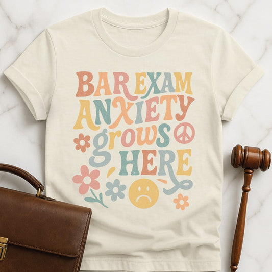 funny law school graduate graphic tee that says bar exam anxiety grows here featuring flowers and peace signs in cream