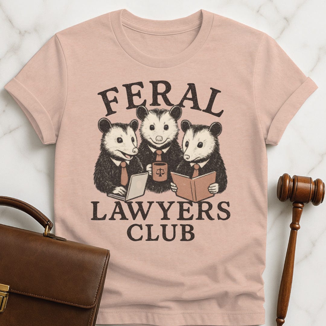 cute attorney graphic t-shirt that says feral lawyers club featuring three possums in business suits and a briefcase in heather peach