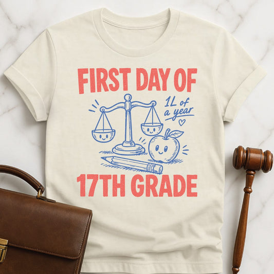 cool law student graphic t shirt that says First Day of 17th Grade 1L of a year featuring apple scales of justice pencil and a heart in cream