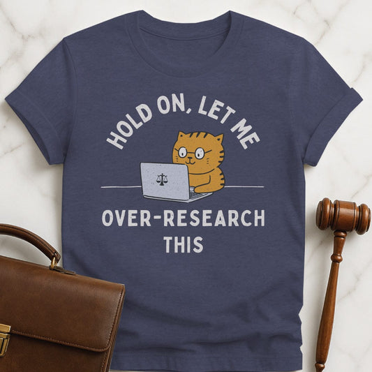 funny new attorney graphic t-shirt that says Hold On let me over research this featuring cat using a laptop with a scales of justice in heather blue