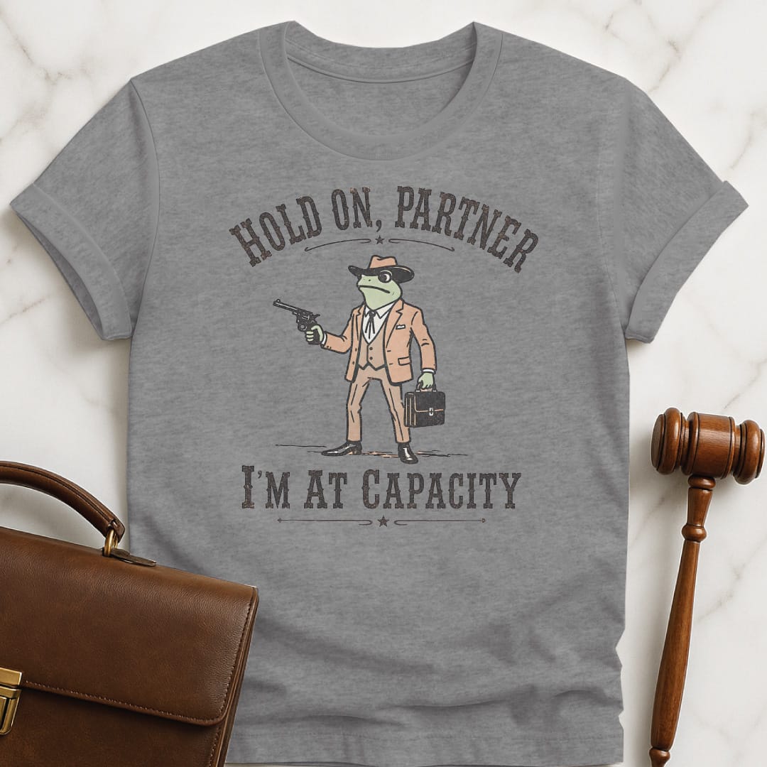 funny law graduate graphic t shirt that says Hold on partner Im at capacity featuring cowboy lawyer toad or frog holding a gun and briefcase in grey