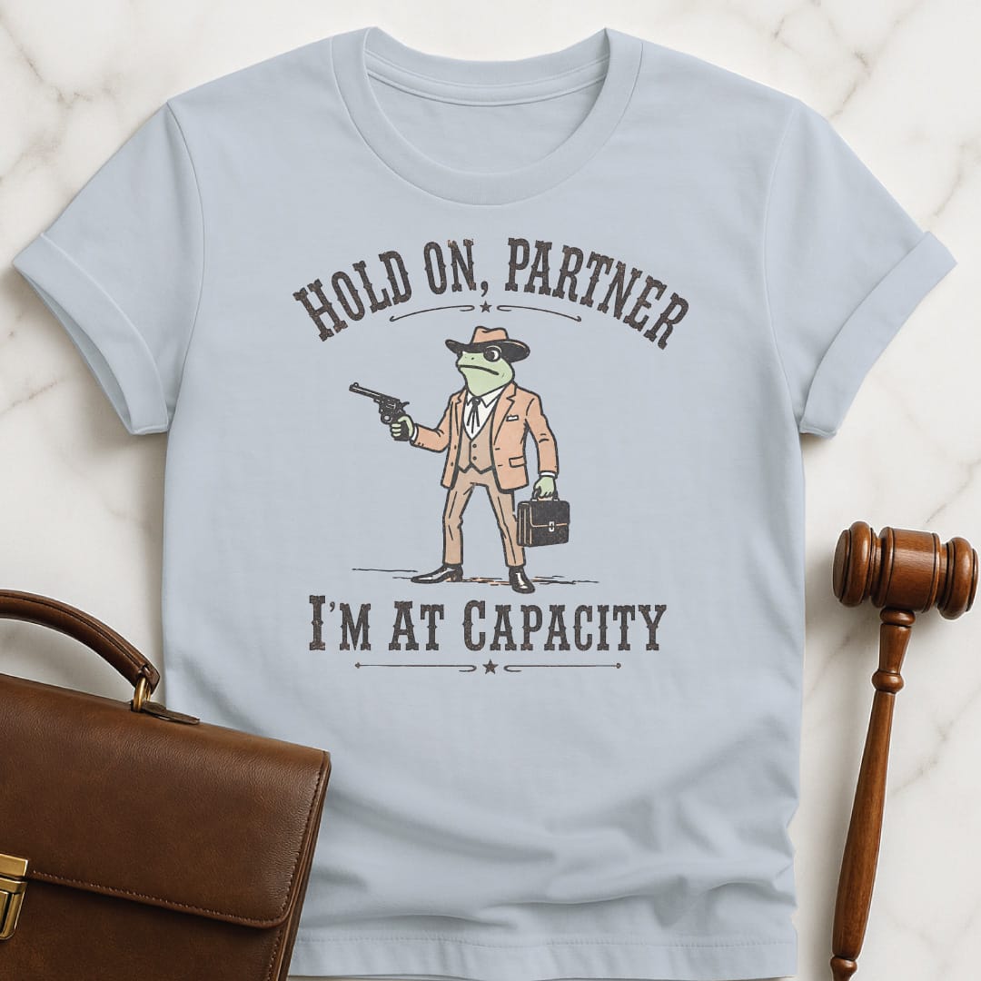 cool new lawyer graphic tshirt that says Hold on partner Im at capacity featuring cowboy lawyer toad or frog holding a gun and briefcase in blue