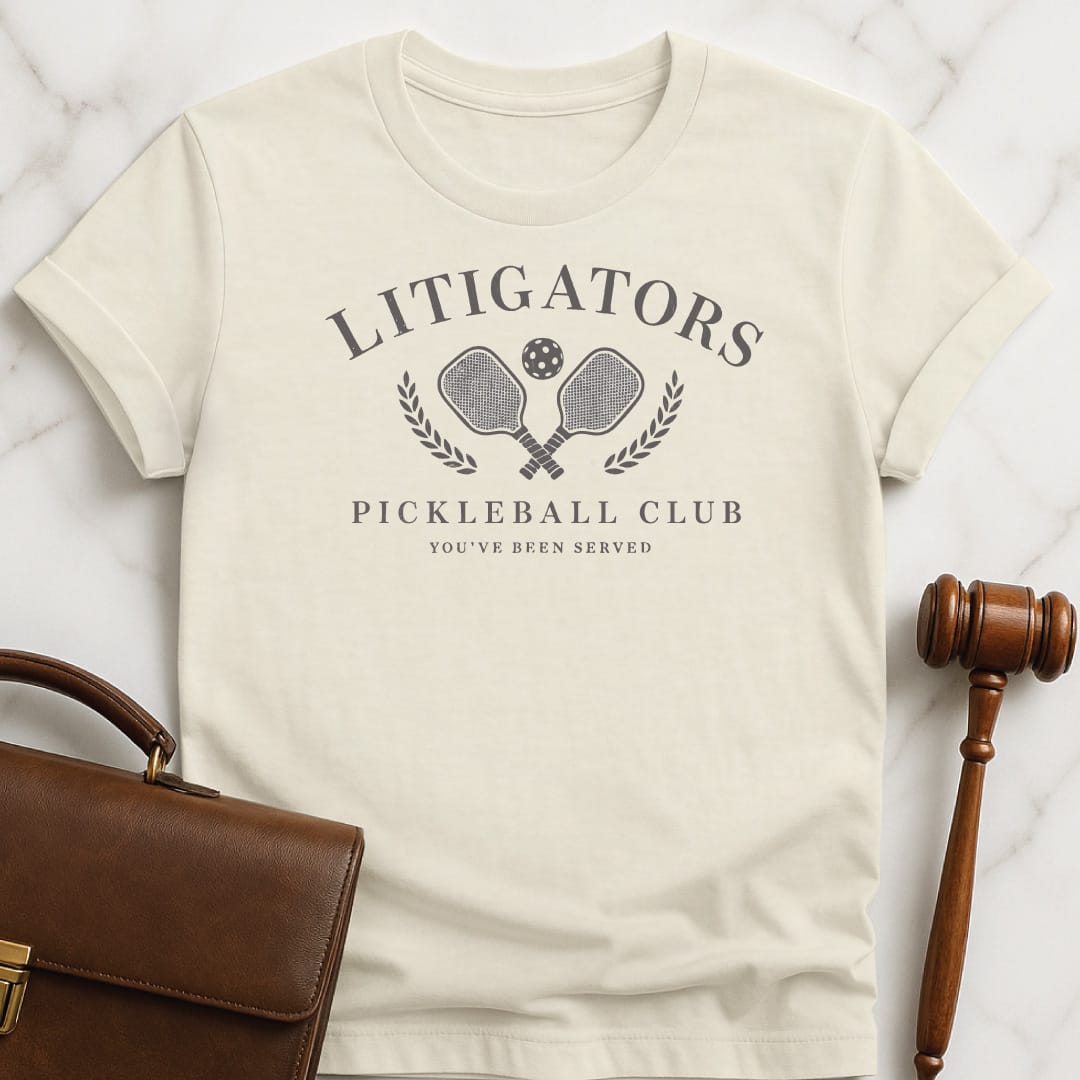 funny law school graduate graphic tshirt that says litigators pickleball club youve been served featuring pickleball paddles and a pickleball ball and a crest in cream