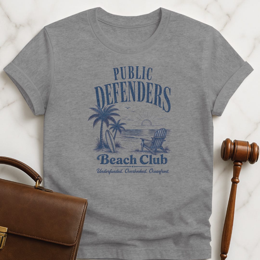 funny new lawyer graphic t-shirt that says Public defenders beach club underfunded overbooked oceanfront featuring beach with palm trees and beach chairs in grey