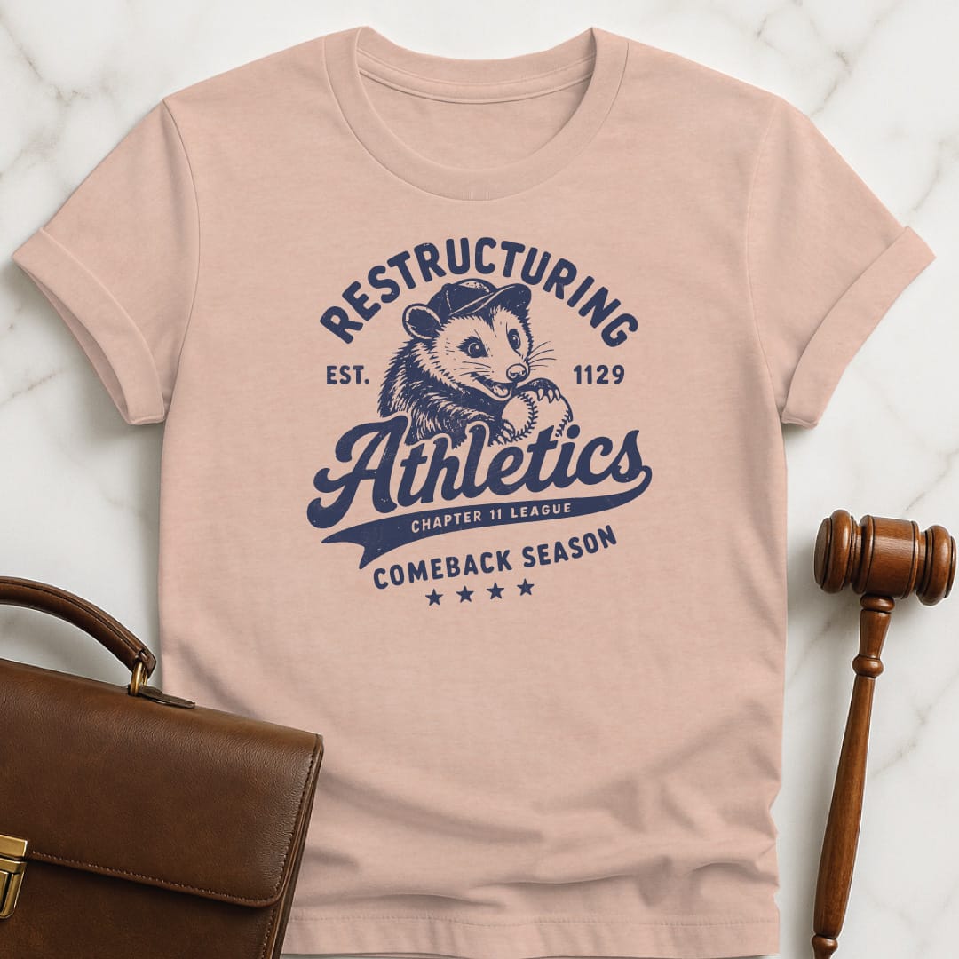 funny attorney graphic tshirt that says Restructuring Athletics est 1129 comeback season chapter 11 league featuring possum with a baseball hat and baseball in heather peach
