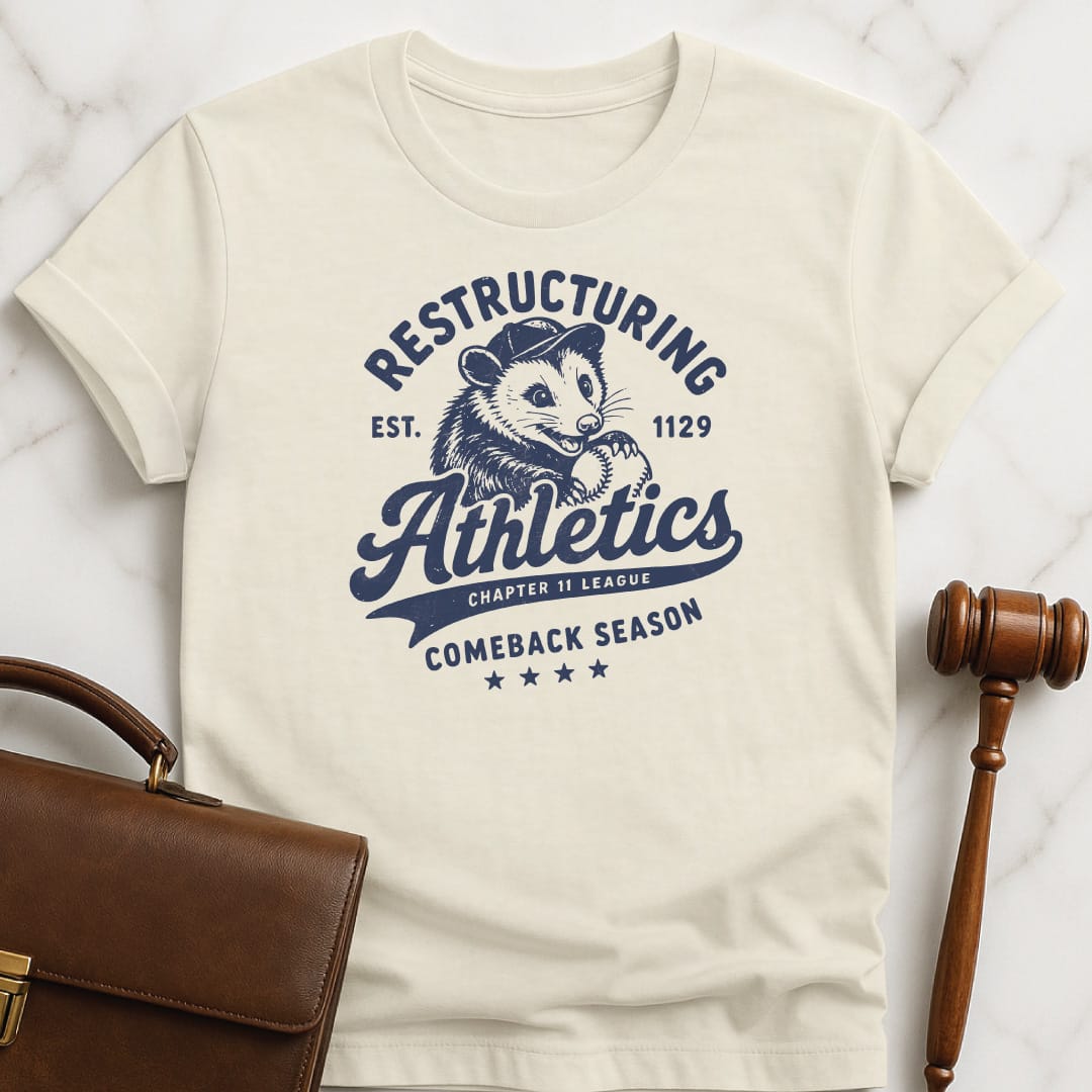 funny attorney graphic t-shirt that says Restructuring Athletics est 1129 comeback season chapter 11 league featuring possum with a baseball hat and baseball in cream
