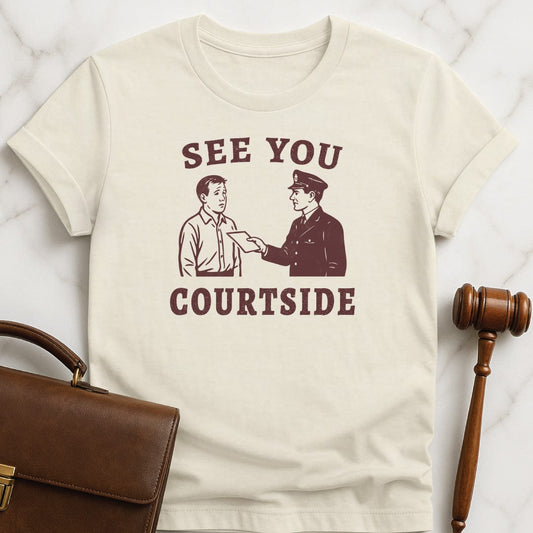retro law student tshirt that says See You Courtside featuring police officer handing a person a piece of paper in cream