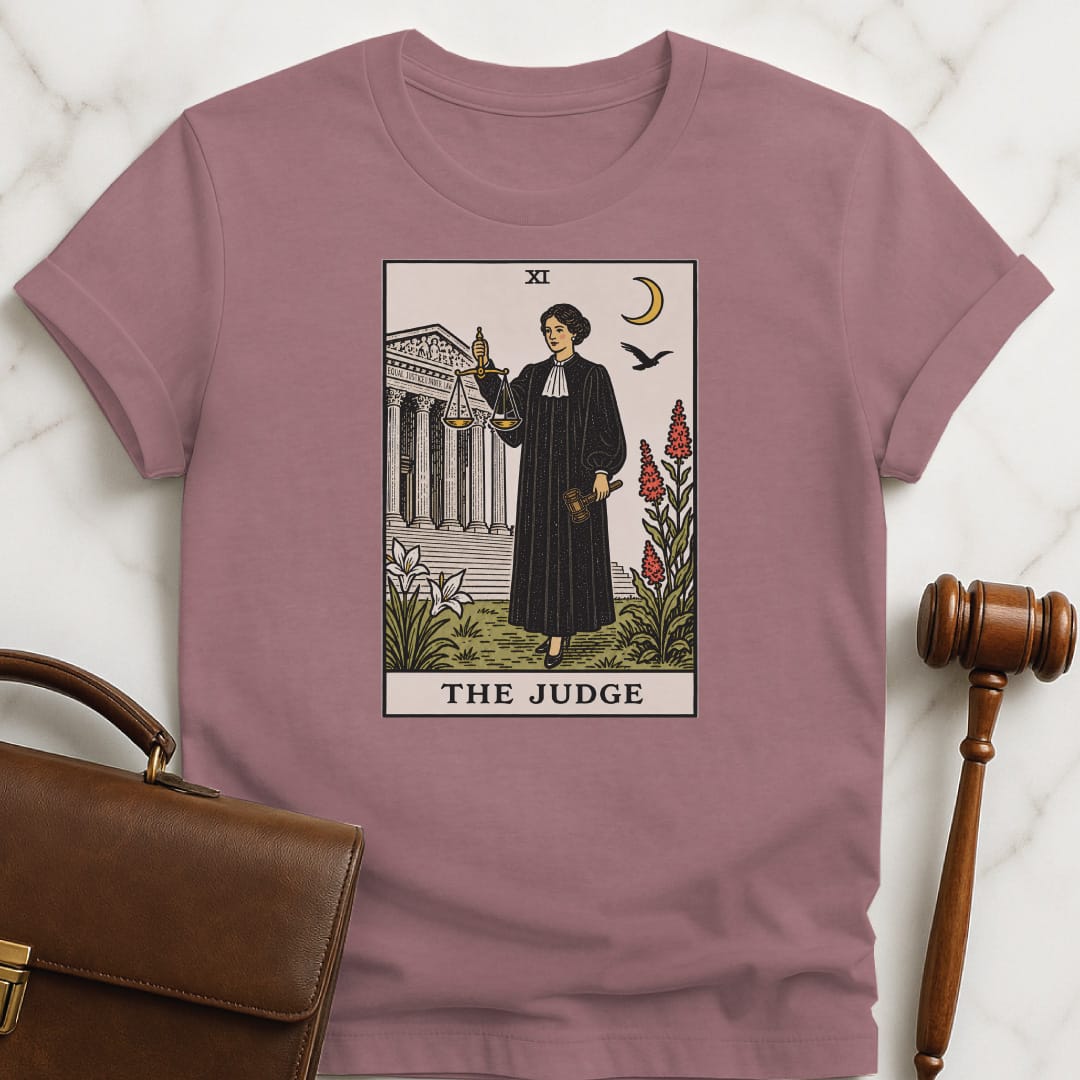cool law grad tshirt that says The Judge featuring tarot card style of a woman judge holding a scales of justice and gavel in front of courthouse in heather mauve