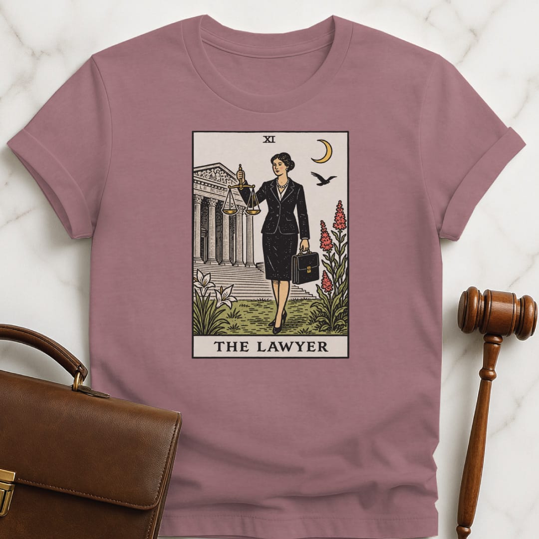 cool lawyer graphic tshirt that says The Lawyer featuring tarot card style of a woman lawyer holding a scales of justice in front of a courthouse in heather mauve