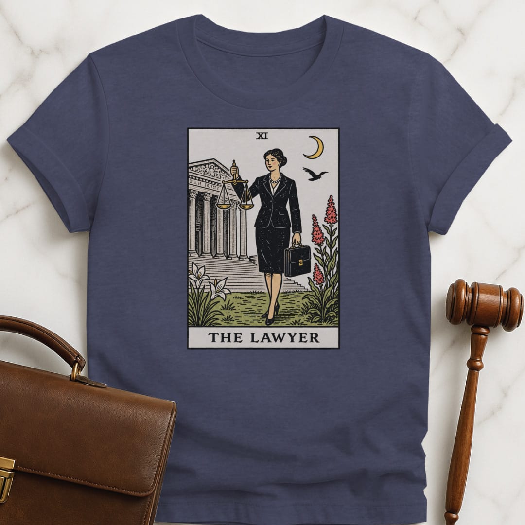 unique law graduate tee that says The Lawyer featuring tarot card style of a woman lawyer holding a scales of justice in front of a courthouse in heather blue