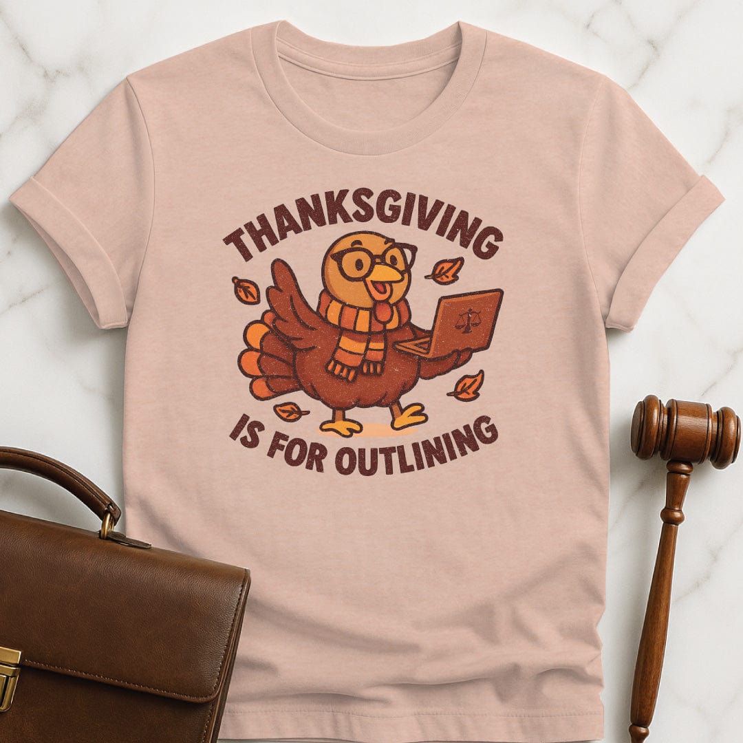 cute law school t shirt that says thanksgiving is for outlining featuring a turkey in a scarf and glasses holding a laptop in heather peach