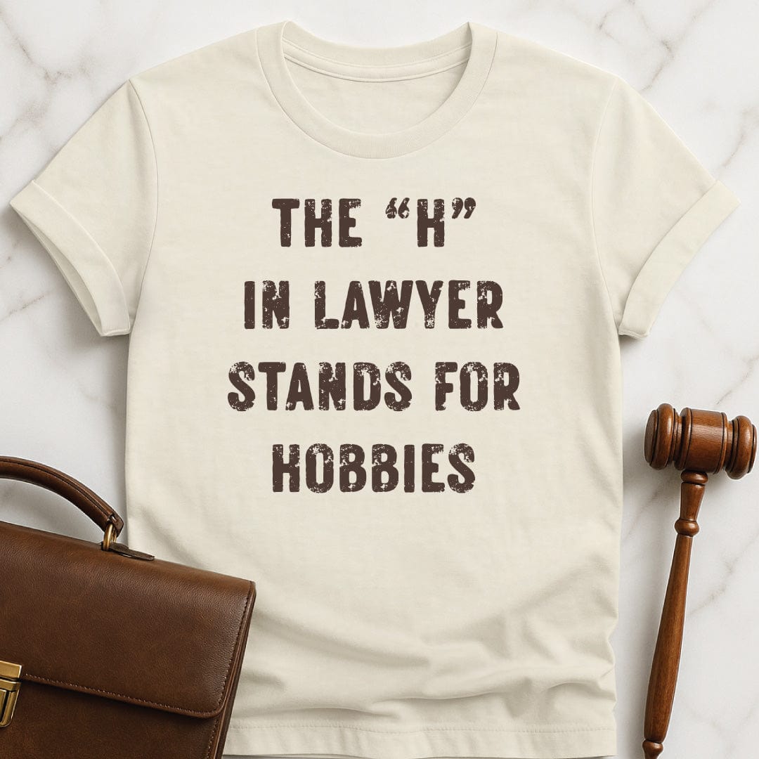 funny law graduate t-shirt that says The H in Lawyer Stands for Hobbies in cream
