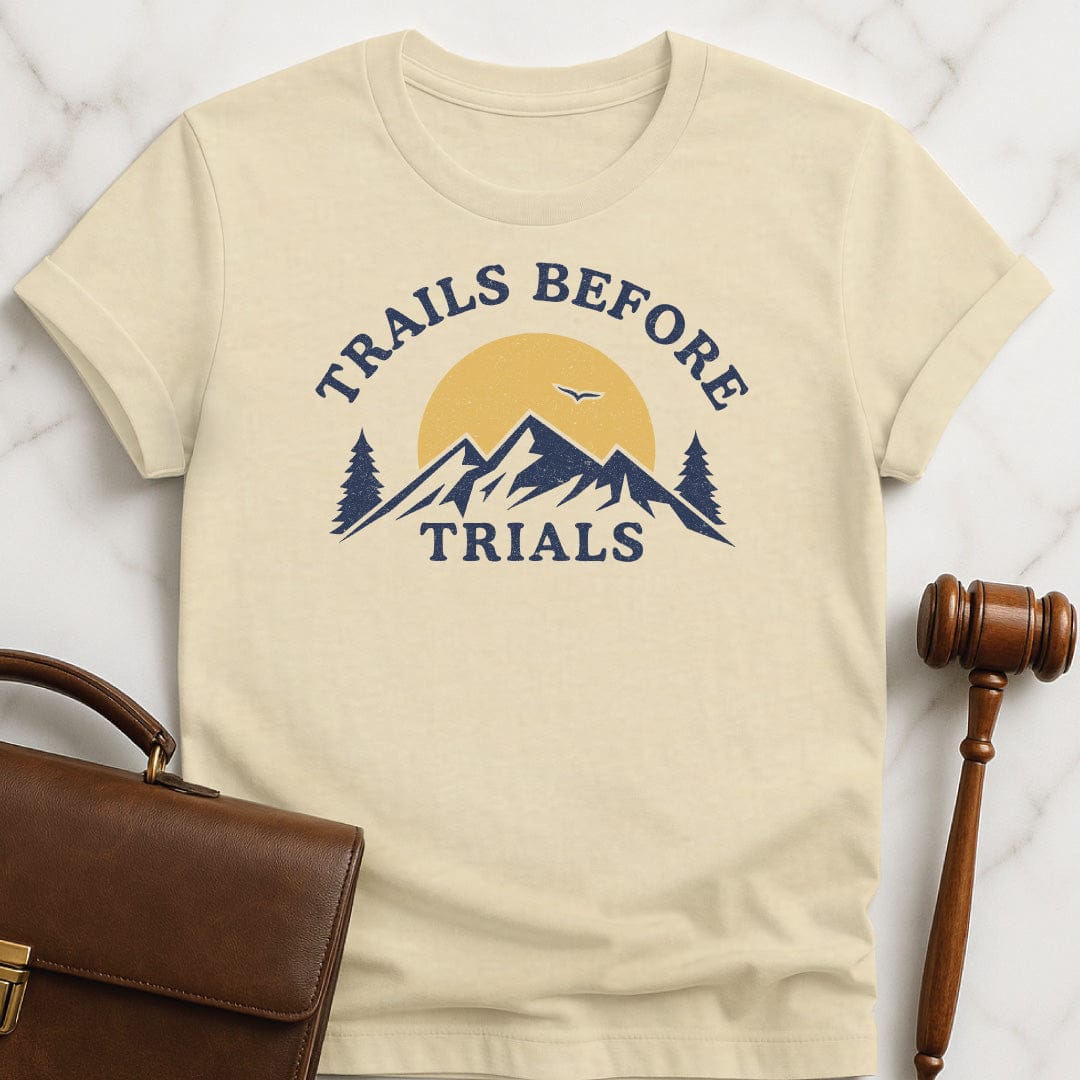 cool law school grad graphic tshirt that says trails before trials featuring mountain sun and a flying bird in cream