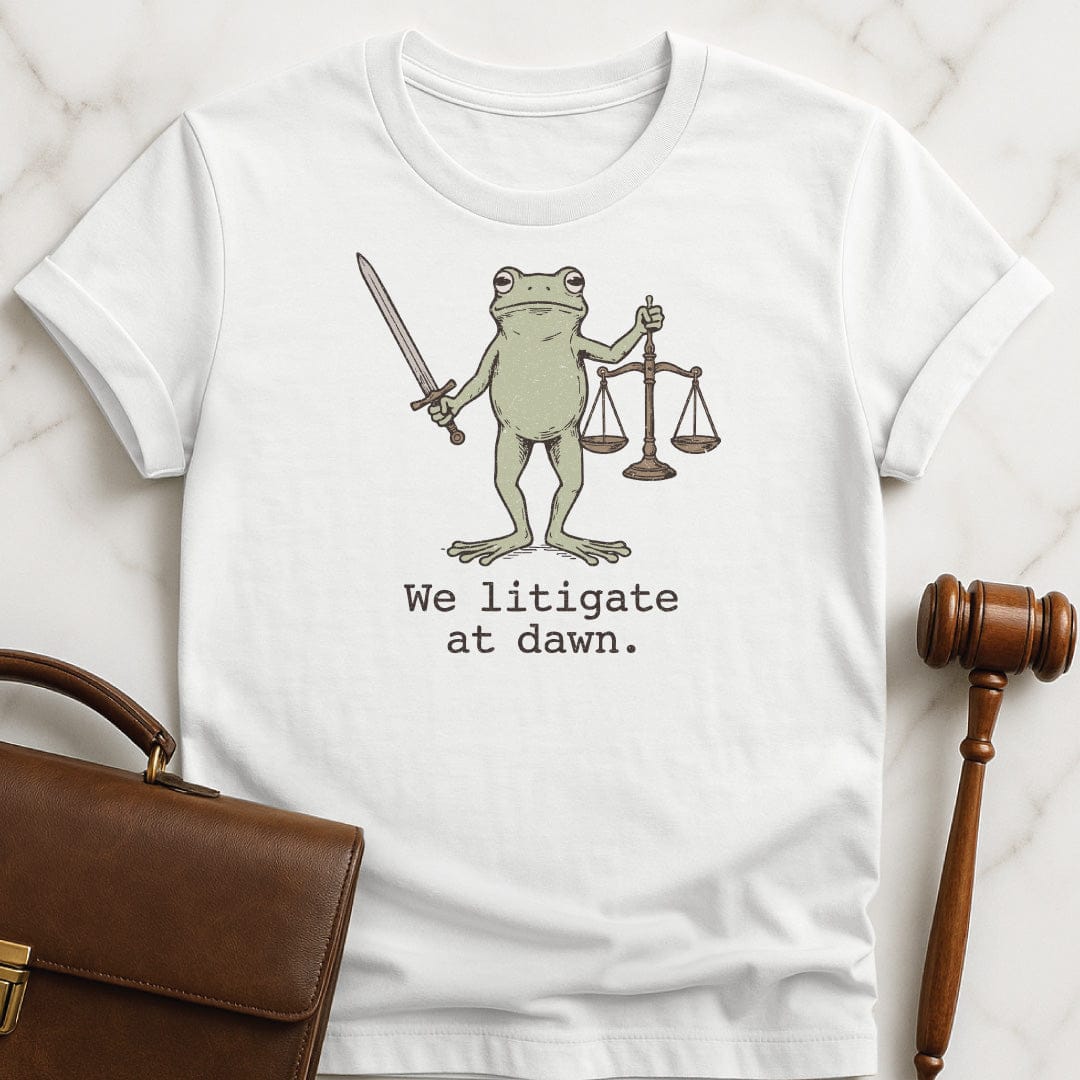funny law student tee that says We litigate at dawn featuring frog with a sword and scales of justice in white