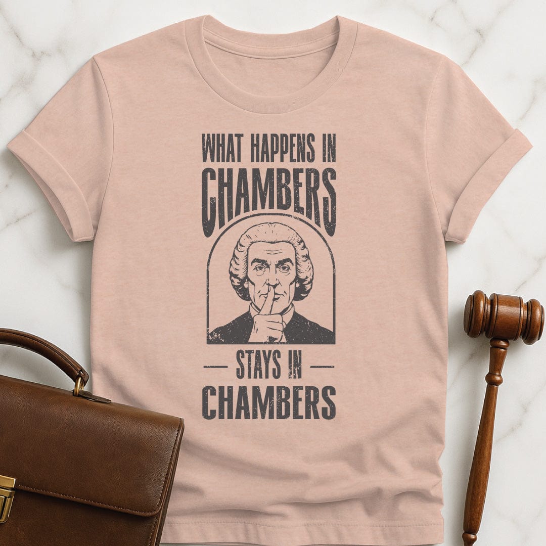 cool law school tee that says what happens in chambers stays in chambers featuring a judge with his fingers to his lips in heather peach