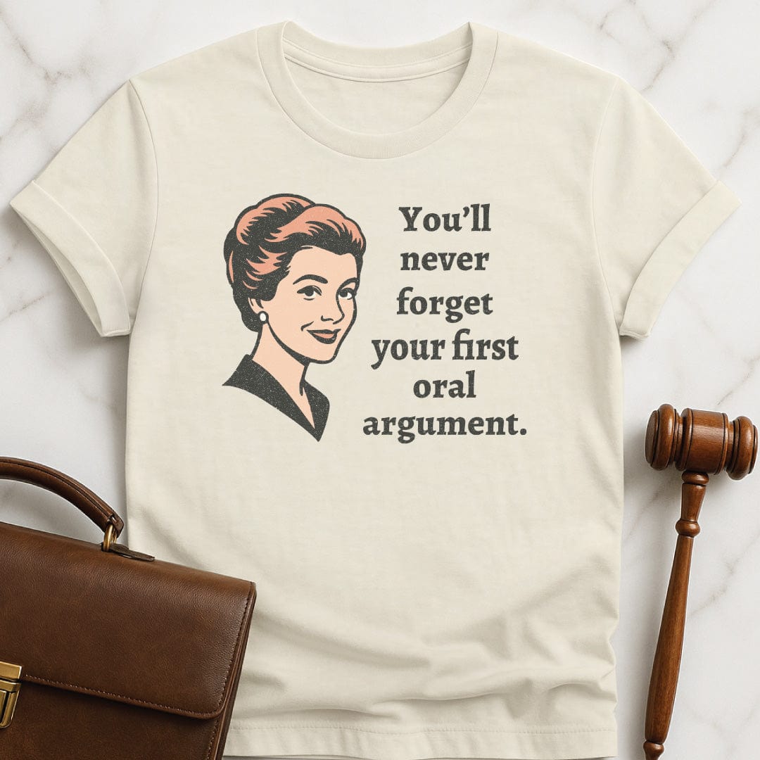 retro law school graduate graphic tee that says You Never Forget Your First Oral Argument featuring A retro woman in cream